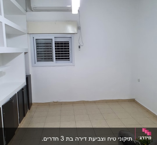 חדר עם קירות לבנים ורצפת אריחים